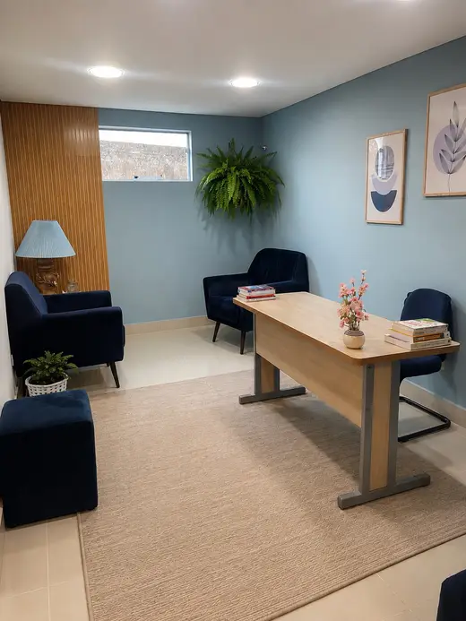 Consultório da clínica, com poltronas, mesa de atendimento e luz indireta