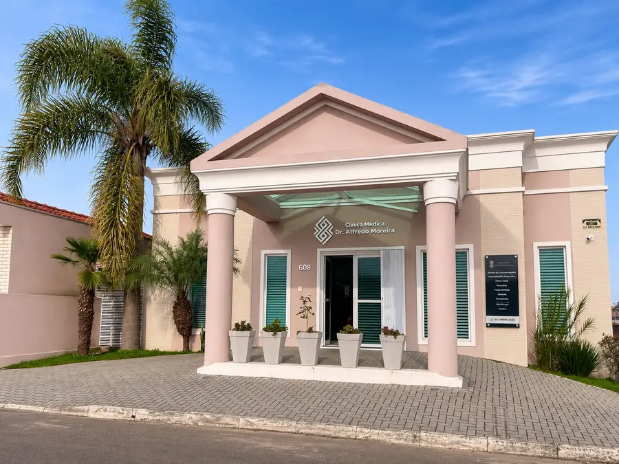 Fachada da Clínica Médica Dr. Alfredo Moreira: prédio rosa com colunas e frente calçada, no Centro da Lapa/PR